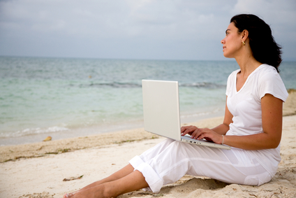 Woman working at the beach Woman working on a computer at the beach